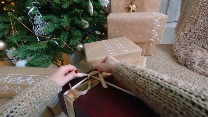 女人在圣诞礼盒上缠丝带
