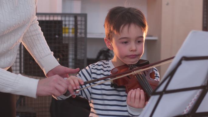 教小男孩拉小提琴的年轻女子