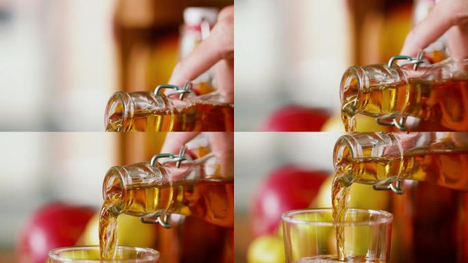 把苹果汁从瓶子里倒到玻璃杯里