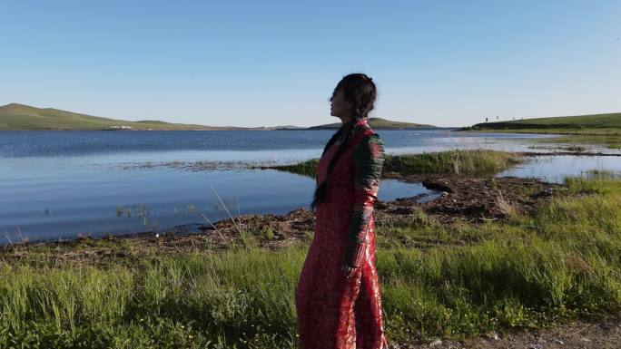 航拍内蒙古草原湖泊边上穿蒙古袍的女人