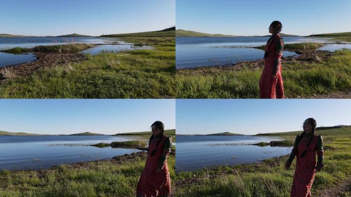 航拍内蒙古草原湖泊边上穿蒙古袍的女人