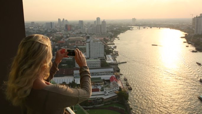女人拍下城市、河流的照片
