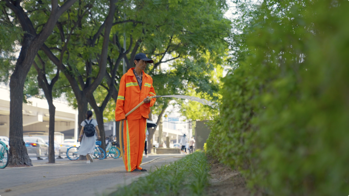 环卫工人给路边花草浇水