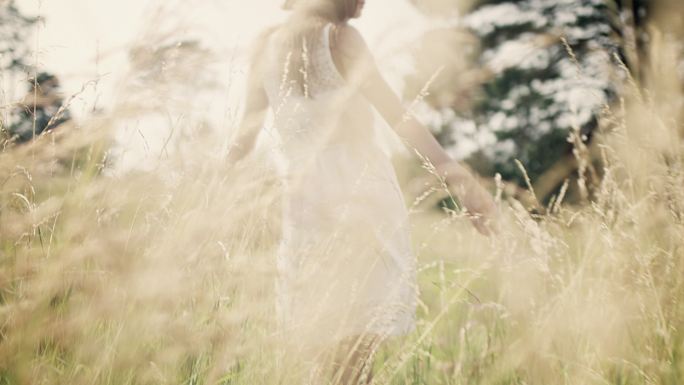 草地上的女人草丛白纱裙张开手臂