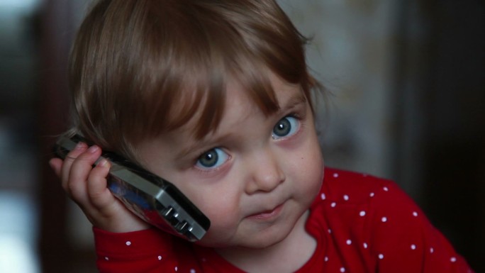 一个婴儿在接电话纯真智能手机成人模仿