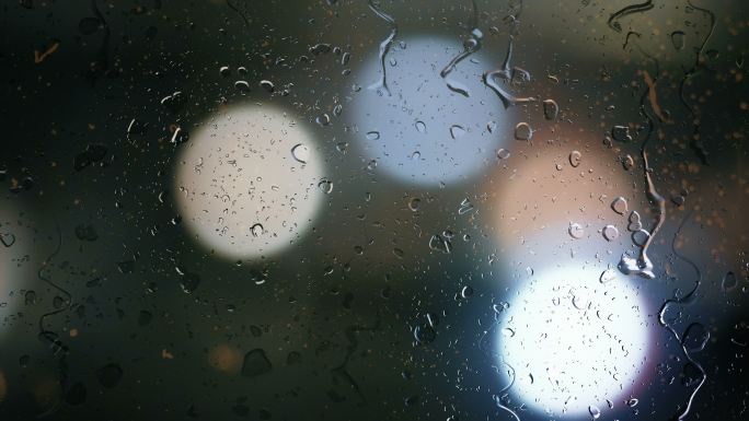 车窗上的雨滴，街道交通灯的模糊背景
