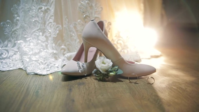两枚结婚戒指在新娘的婚鞋旁滚动