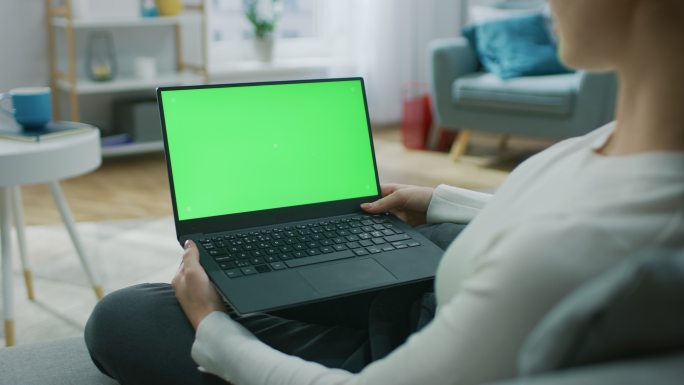 在使用绿色屏幕笔记本电脑的女人