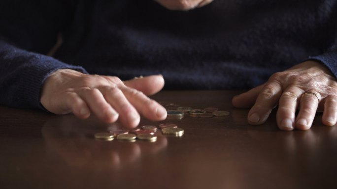退休老太太在桌子上数硬币