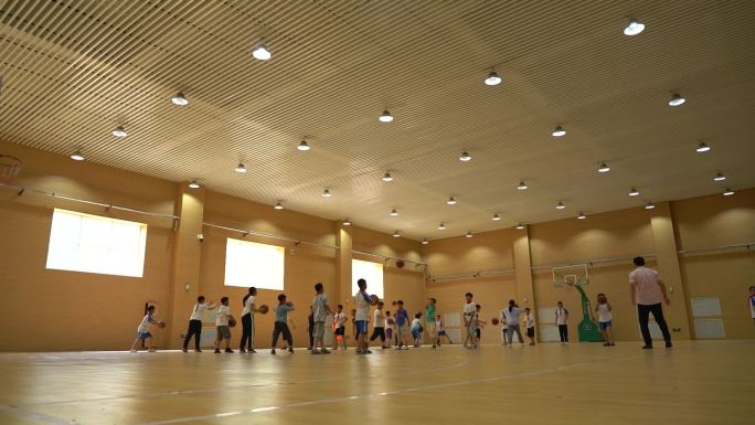 一群小学生在篮球馆练习打篮球篮球课