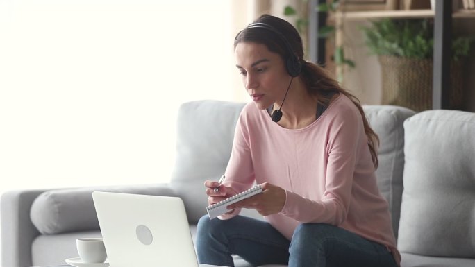 戴耳机带麦克风的女士与老师在线学习英语