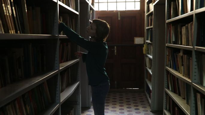 一个女人在书架上找书