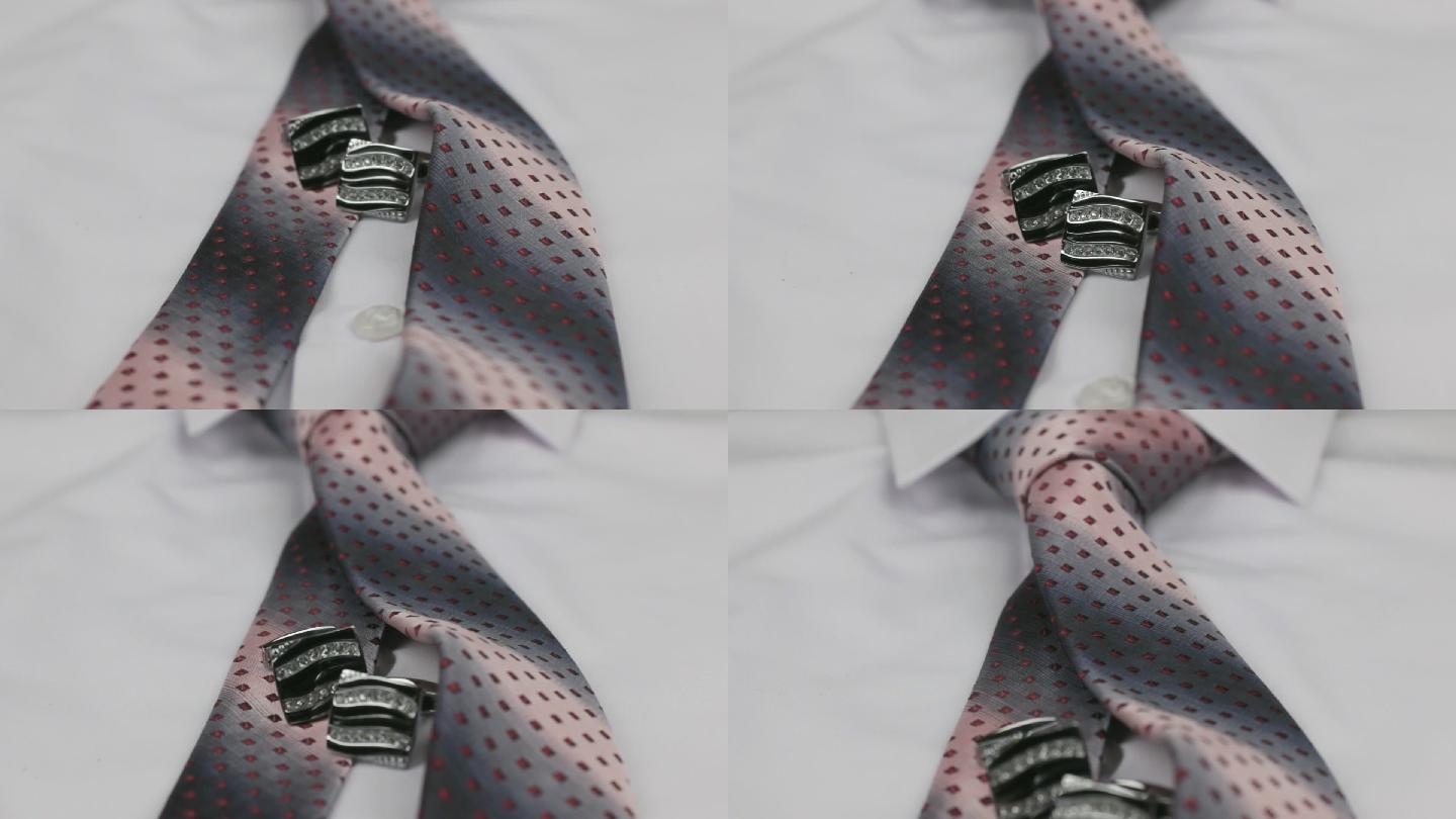 特写白色衬衫上打结的粉色领带和袖扣。