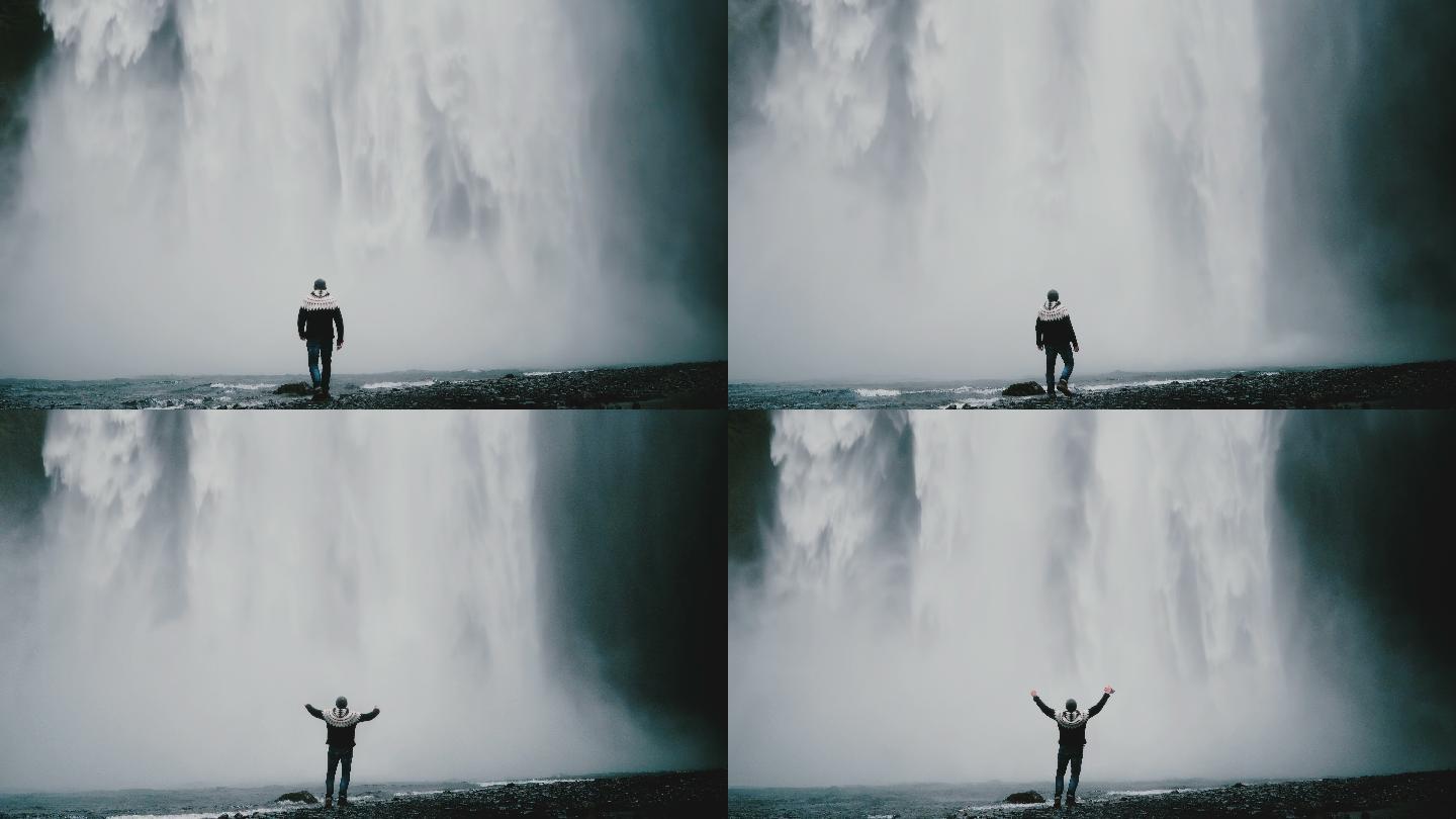 游客在瀑布附近，举起双手，感到喜悦。