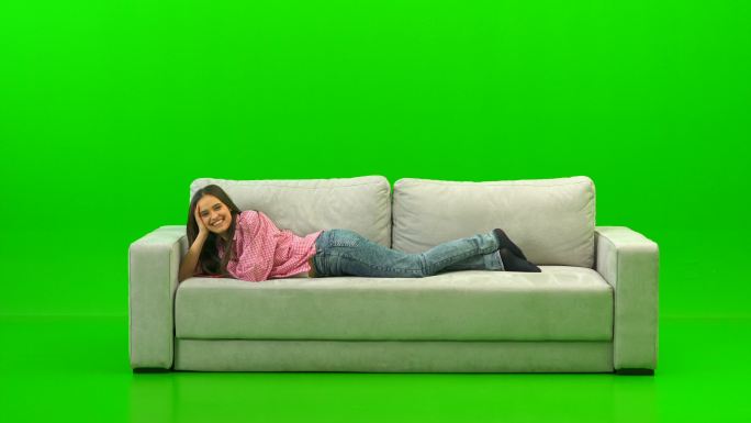 躺在绿色背景沙发上的女人
