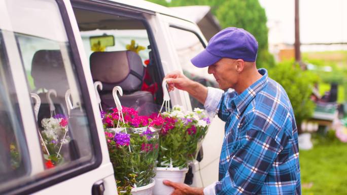 农民双手捧着鲜花放进车里