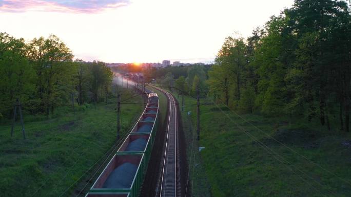 日落时分，一列货运火车穿过树林