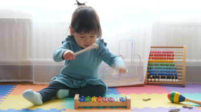 小女孩在家玩木琴小孩玩具亲自陪伴早教机构