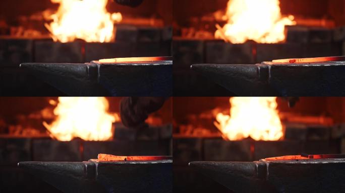 铁匠用大铁锤敲击铁砧上的热金属棒。