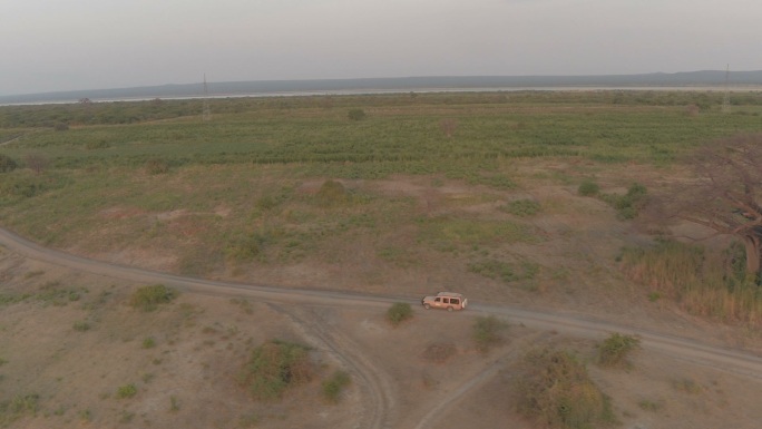吉普车在日出时分穿越非洲稀树草原