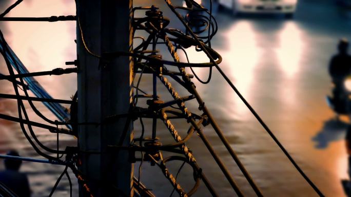 汽车在夜间经过一个有许多电缆的塔架