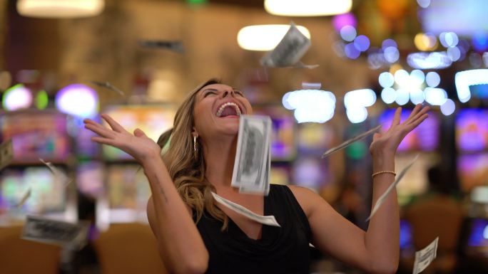 一个快乐的女人在赌场把钱扔到空中