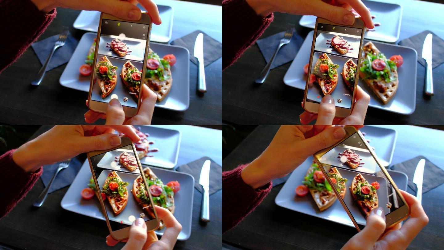 在餐厅里，女性用智能手机拍摄食物