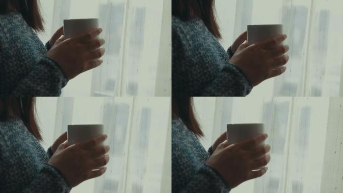 靠近窗户端着咖啡的女人特写镜头