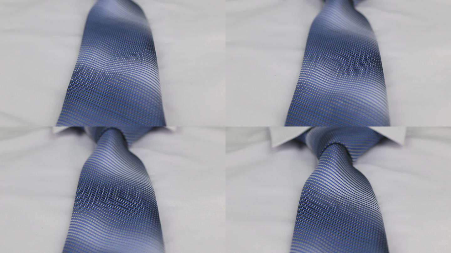特写白色衬衫上打结的蓝色领带。