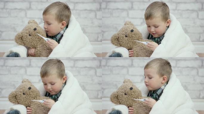 小男孩拿温度计给小熊玩具测体温