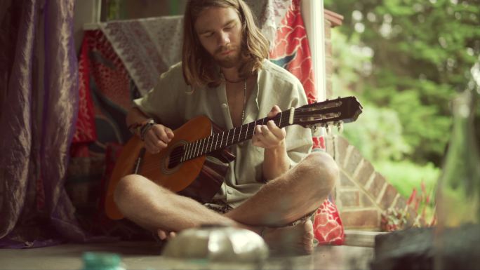 一个长发男人在弹吉他