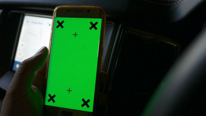司机在车内使用绿色屏幕手机导航