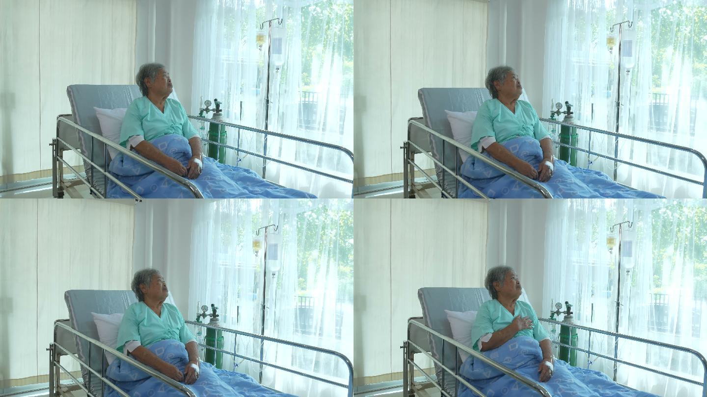 老年女病人坐在病床上担忧地看着窗外