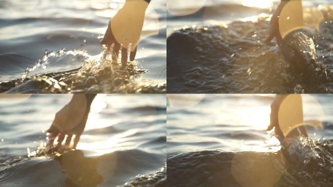 日落时，特写一个女孩在水中移动的手