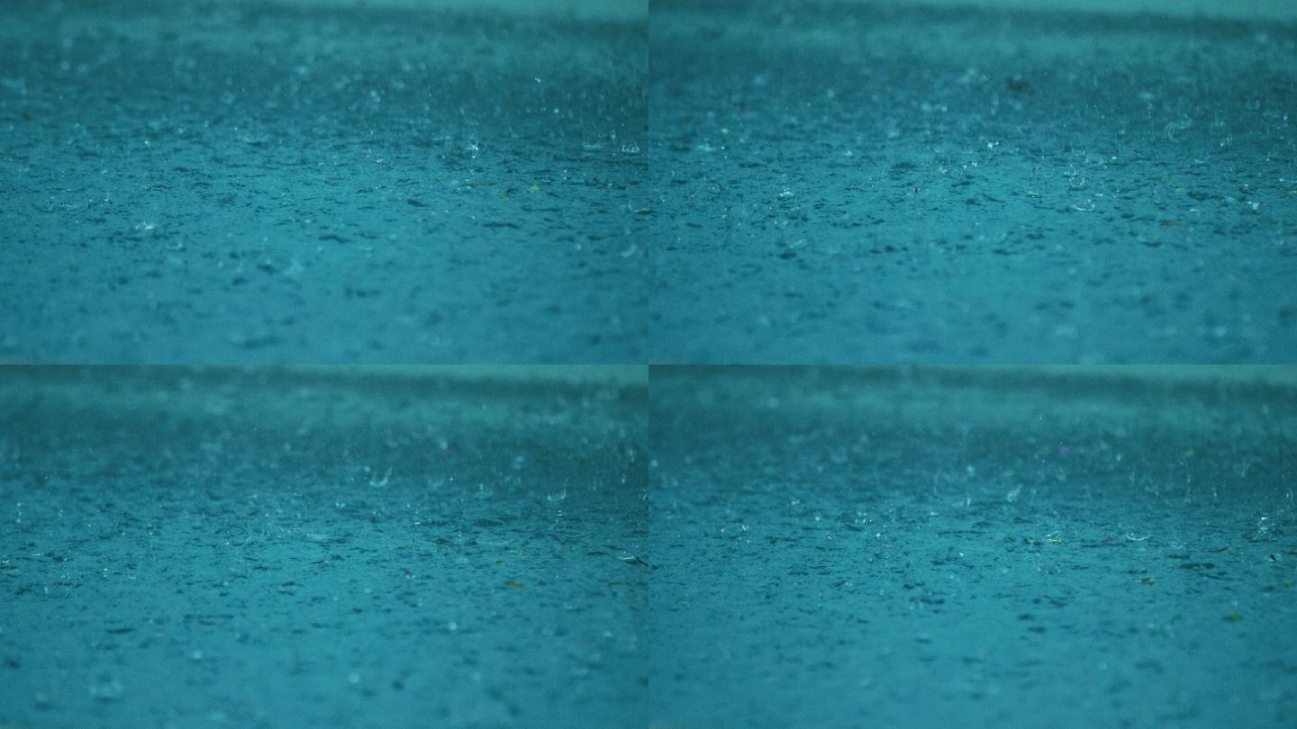 雨滴溅到一个蓝色的水坑里