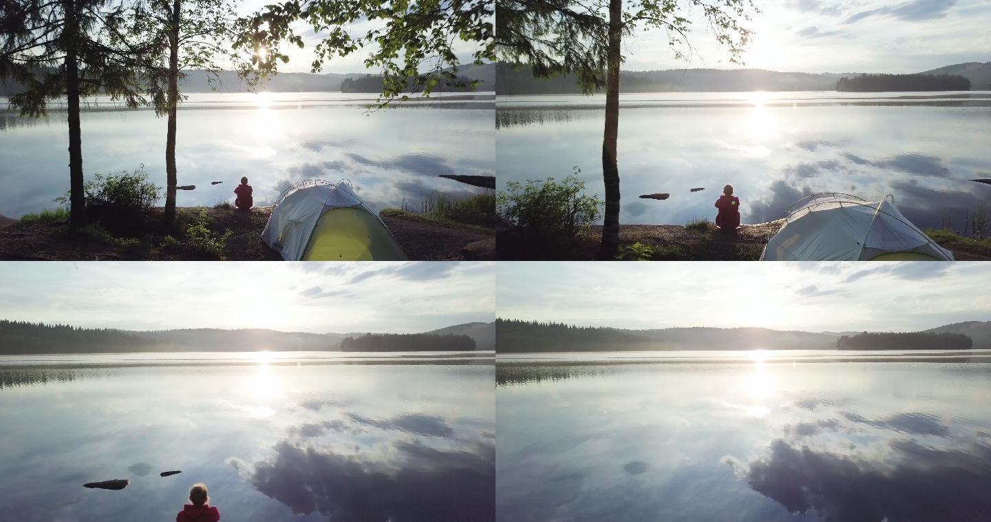 挪威湖边森林里的女人和帐篷