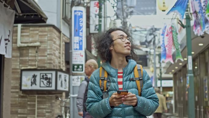 年轻男子在城市里看手机问路的慢镜头