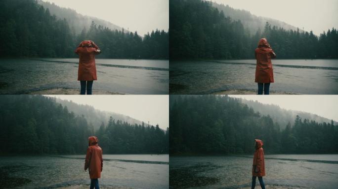 穿着雨衣的女人站在湖边