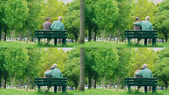 一对老年夫妇坐在公园长椅上相拥