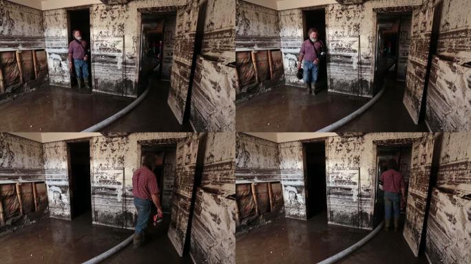 男子走过被洪水淹没的地下室