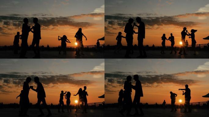 夕阳下，人们在城市堤岸上学习跳舞