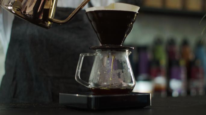 咖啡师把热水倒在磨碎的咖啡豆上