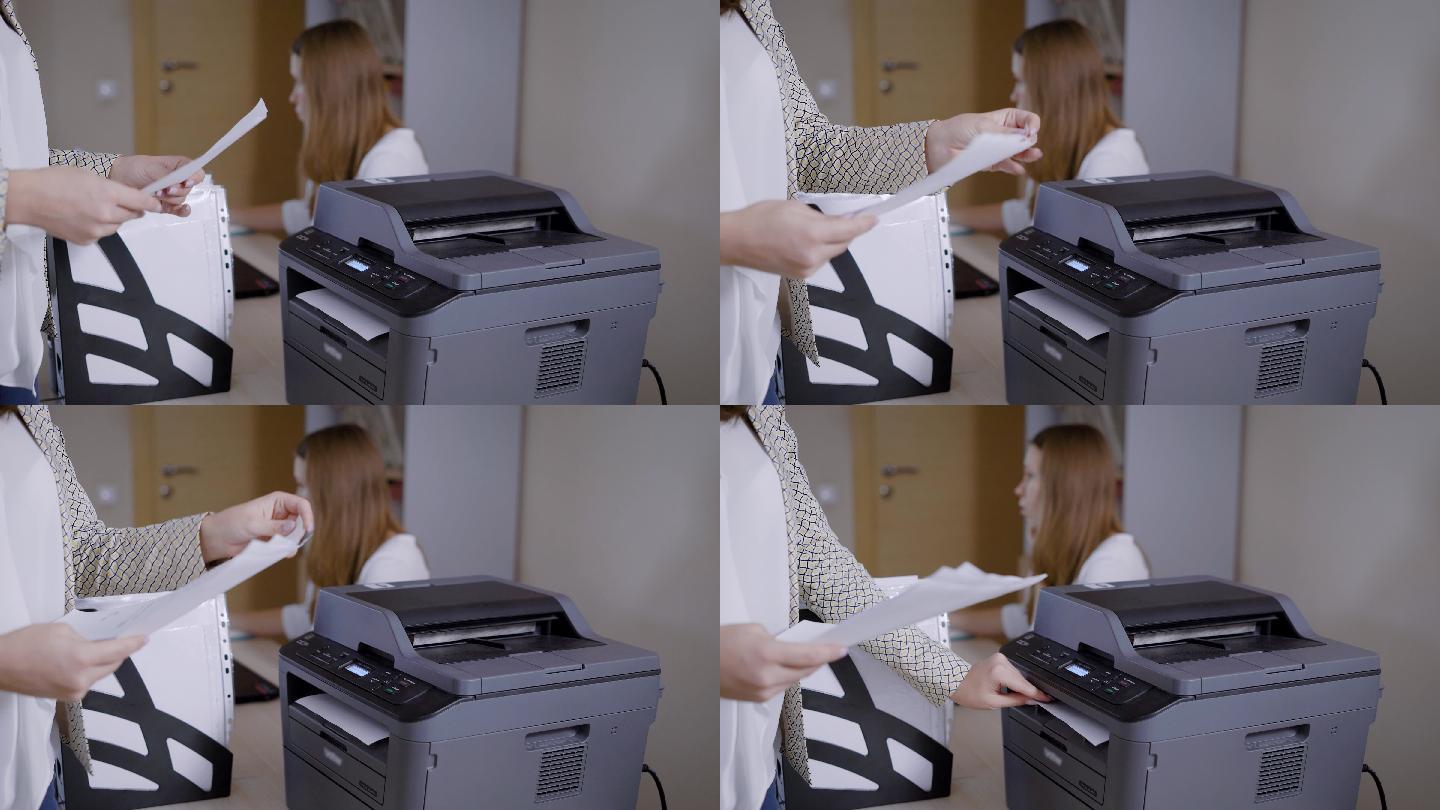 办公室里的一位女士正在从打印机上取文件