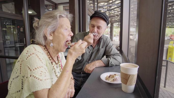 快乐的老年夫妇享受咖啡和蛋糕