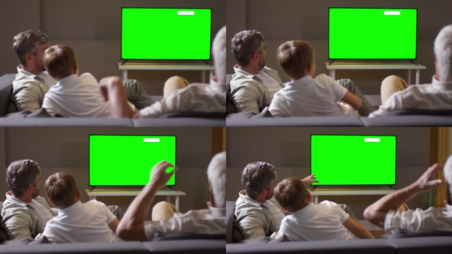 在看绿色屏幕电视的一家人