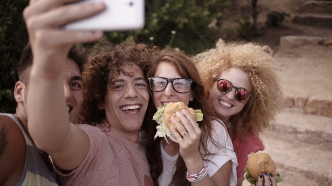 一群朋友吃着汉堡包时的自拍镜头