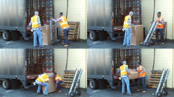 两个工人把大箱子装上运货卡车