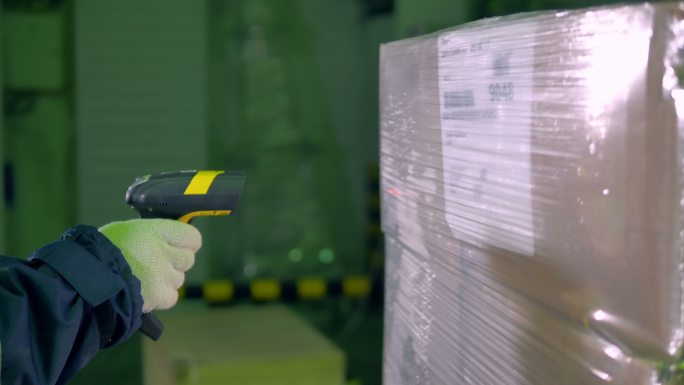 工人在仓库用条形码扫描器检查货物