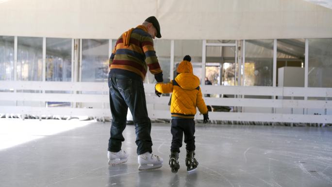 爷爷和孙子在溜冰场滑冰