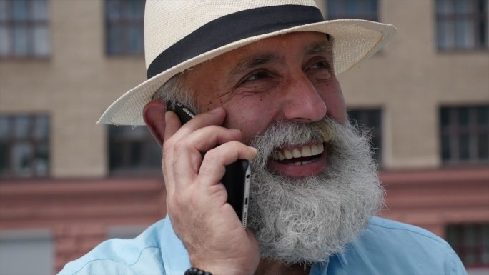 大胡子白发男子在电话中讲话